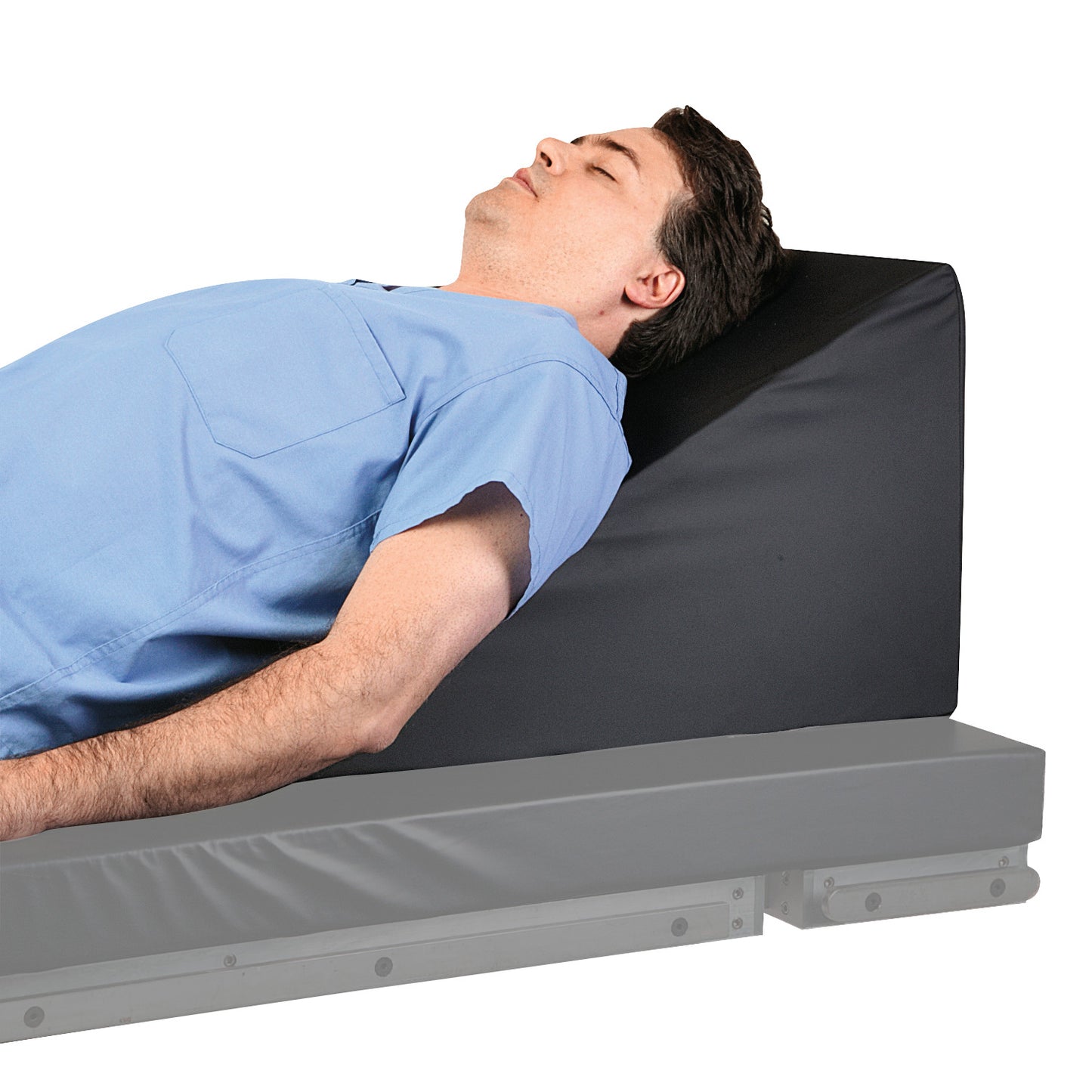 A person reclines against the AliMed Cardiac Foam Wedge, positioned on a bed for support.