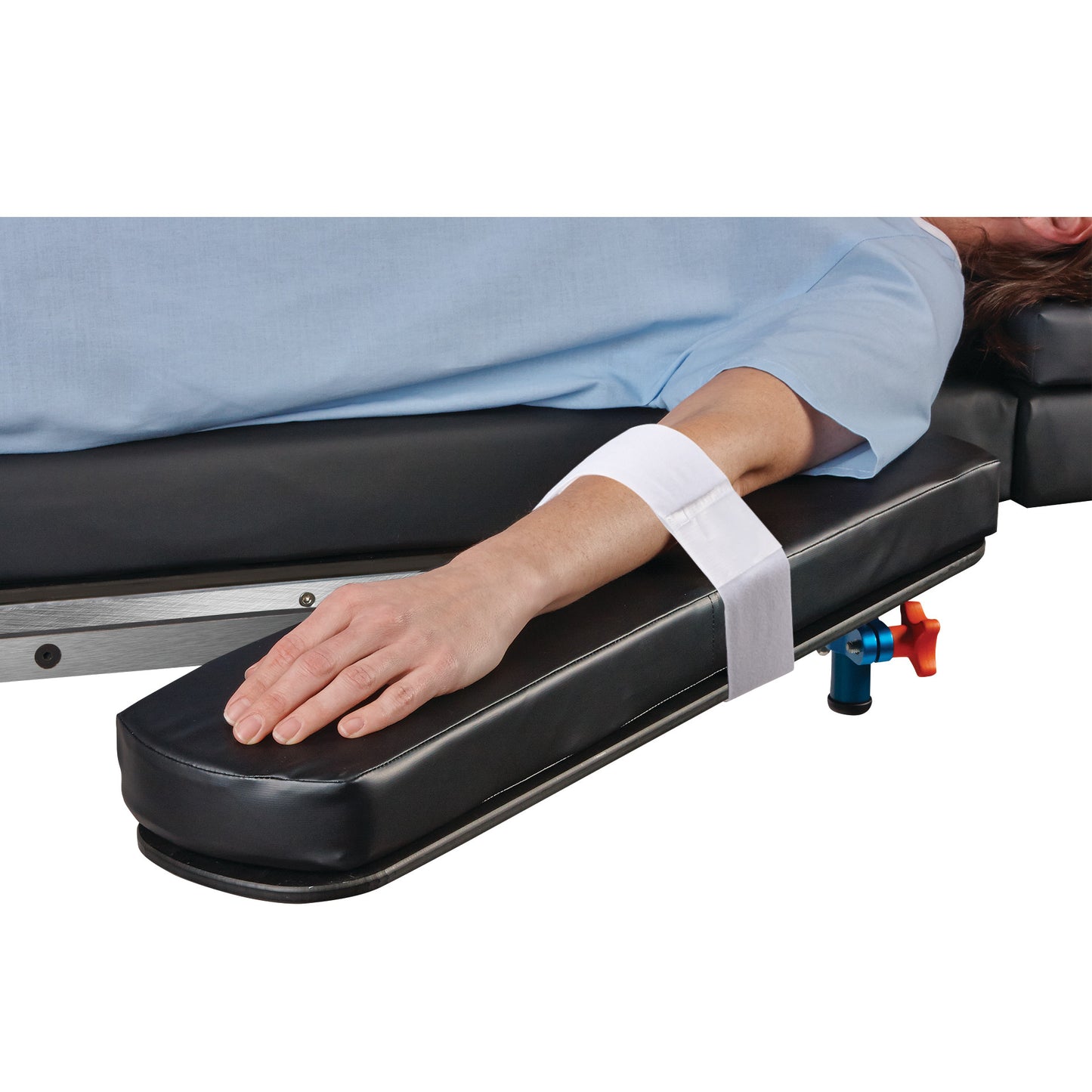 A patient's arm is secured to a padded armboard with the AliMed Soft-Touch Armboard Strap, which is white and wraps around the forearm.