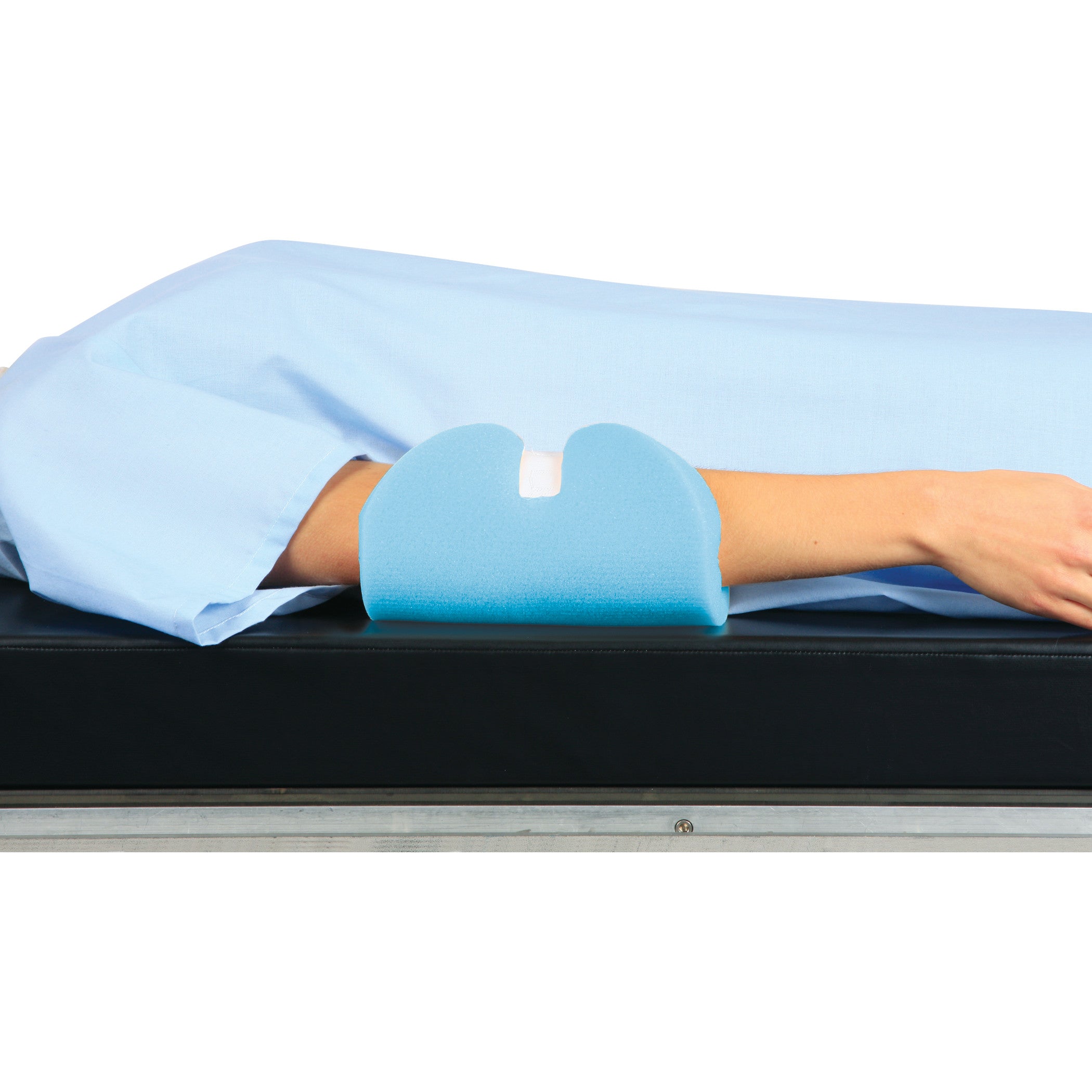 A person's arm is resting on an AliMed Single-Use Ulnar Nerve Protector, a blue foam cushion, on a black surface.