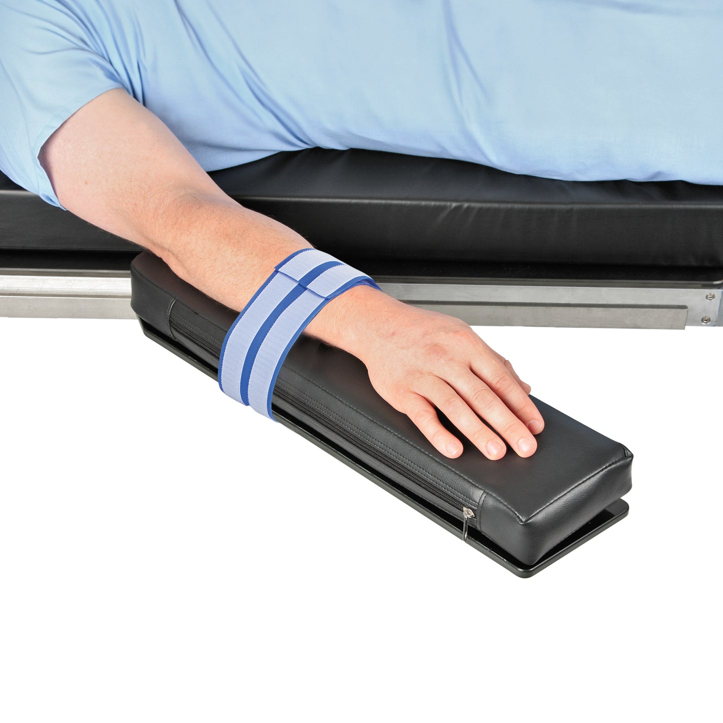 A person's arm is secured on a padded platform using the AliMed AliStrap Positioning Strap, aiding in stability and support.