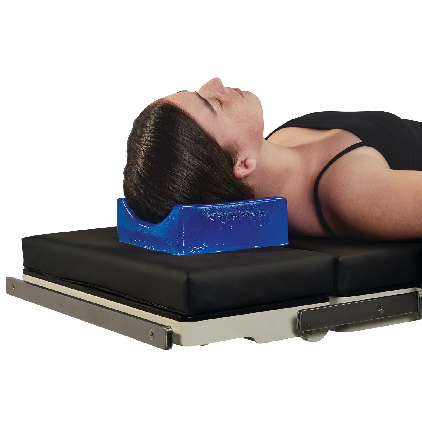 A person is lying on a black surface using the AliMed AliBlue Gel Contoured Headrest, which supports their head and neck.