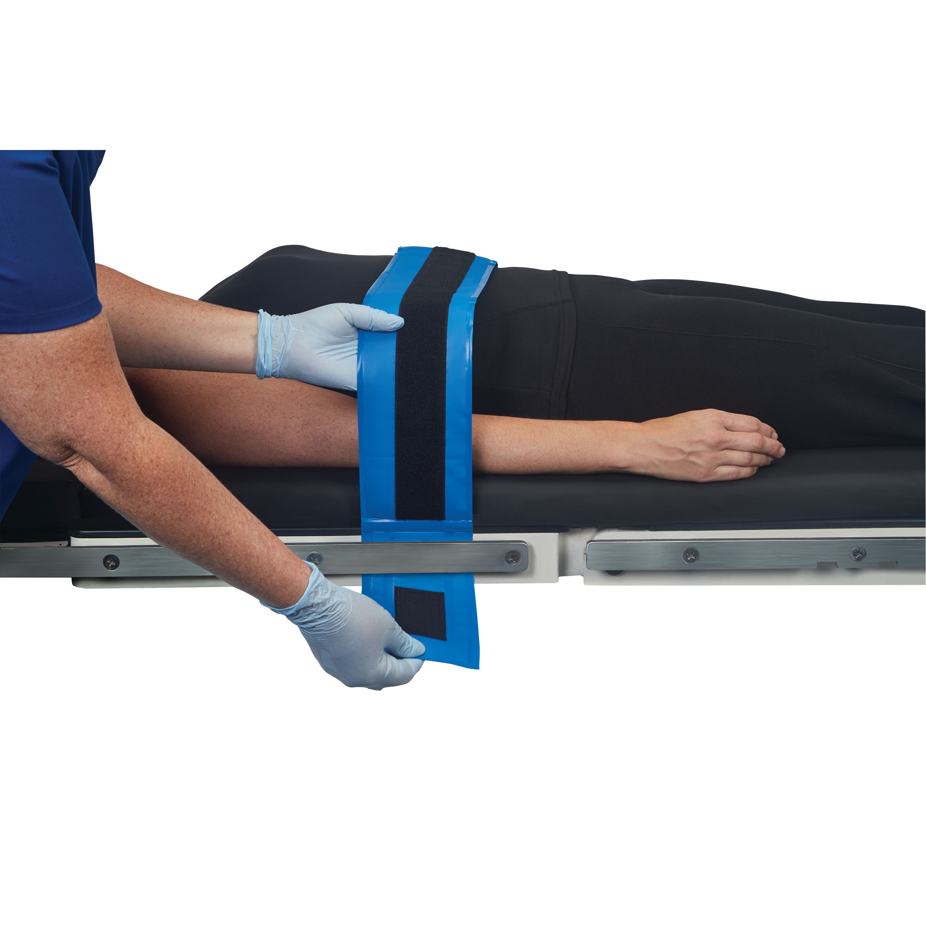 A person secures an arm with the AliMed AliBlue Gel Body Strap on a medical table. The strap is blue with a black center.