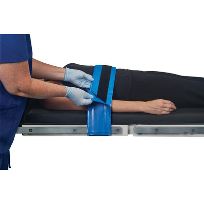A person secures an AliMed AliBlue Gel Body Strap around the arm of a patient lying on an examination table.