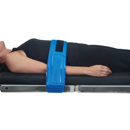 A person lies on a table with an AliMed AliBlue Gel Body Strap securing their arm, showing use for stabilization and comfort.