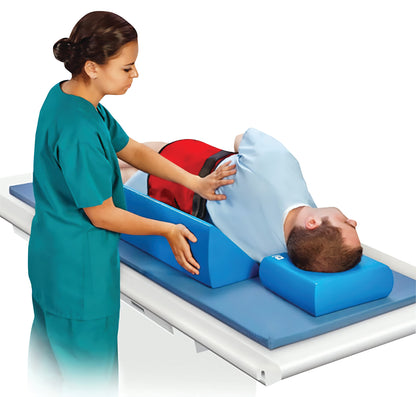 A caregiver positions a patient using the AliMed InvisiCoat Plus 45 Degree Wedge, supporting their back on a medical table.