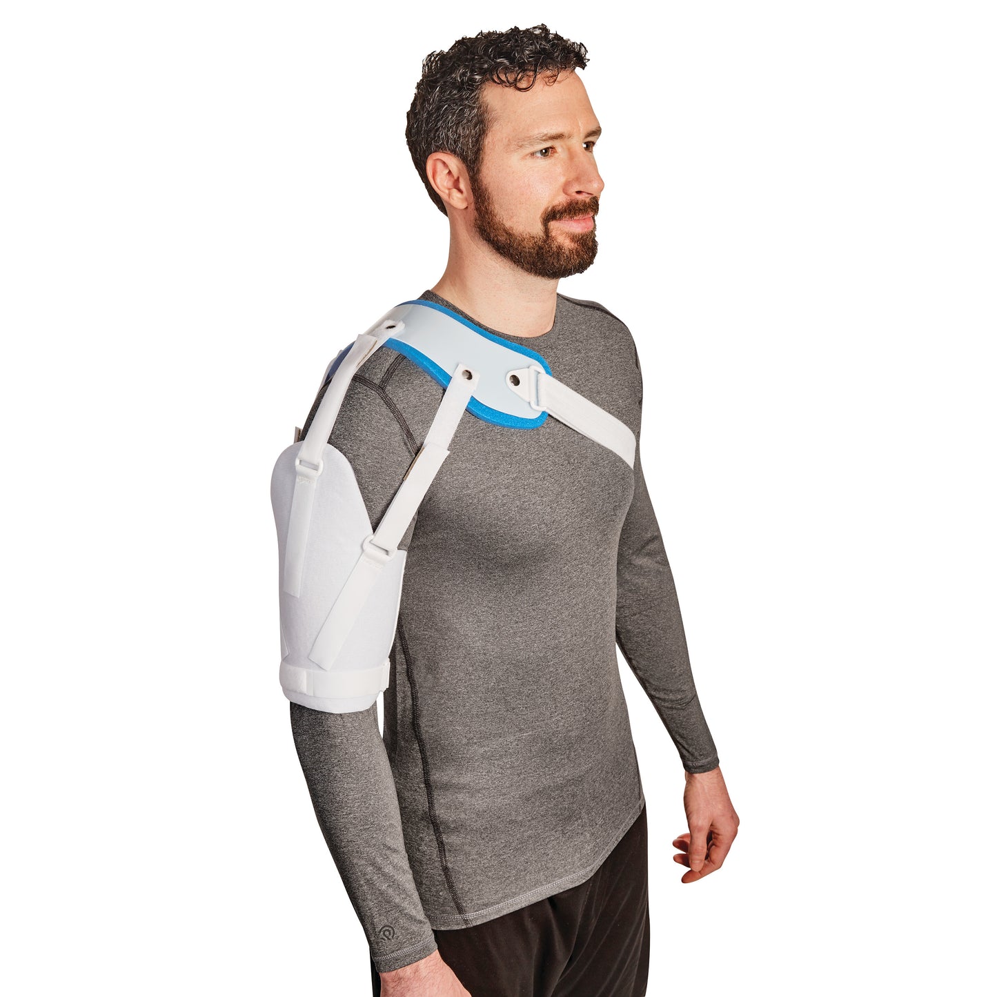 A person wears the AliMed Hemi-Shoulder Sling, which supports and immobilizes the shoulder. It features white straps and padding.
