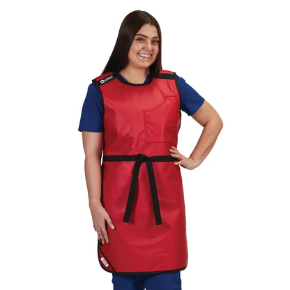 A woman wearing the AliMed Grab n Go Tie Apron, Female in red, with a pocket and black tie, over blue scrubs, smiling.