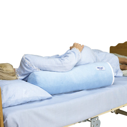 A person lies on a bed using the SkiL-Care Ultra-Soft Bed Bolster, a blue, cylindrical cushion, for side support.