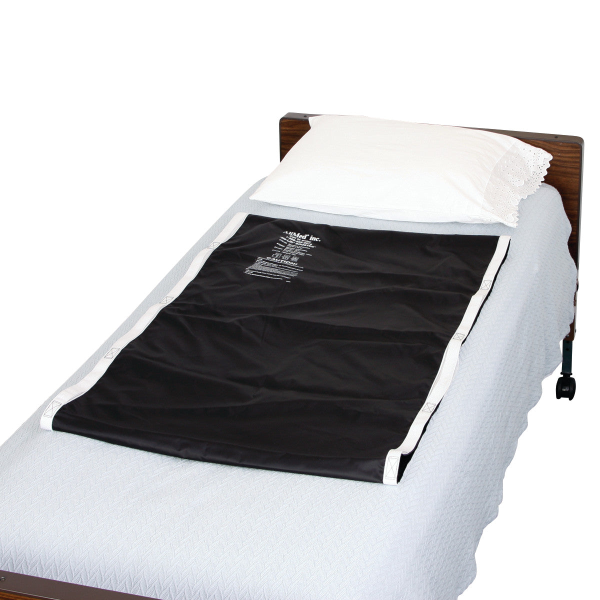 A hospital bed with an AliMed No-Lift BOOSTER pad on the mattress, covered by a white pillow and light blue bedding.