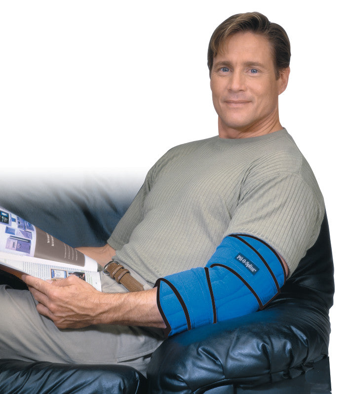 A man uses the Brownmed IMAK RSI Pil-O-Splint Adjustable Elbow Support while sitting and reading a magazine.