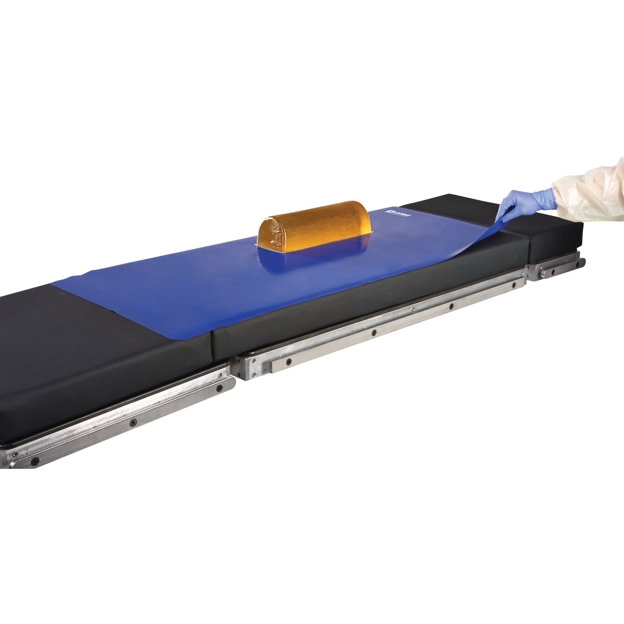 An AliMed Nonslip Surface Overlay on a medical table, featuring a blue mat with a yellow cushion on top.