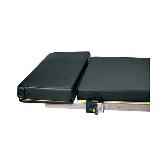 The Allen Foot Extension, a padded platform extension, is attached to a medical table, featuring a black cushion and safety latch.