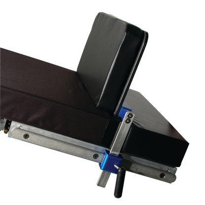 AliMed Foot Extender attached to a table or chair, featuring a black cushioned surface and metallic adjustment mechanisms.