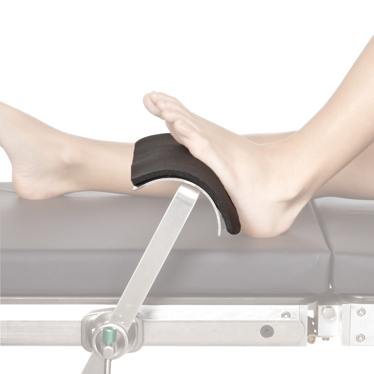 A person's foot is resting on a hospital bed footrest with a PAD FOOT ADHESIVE DISP FOR TKR FOOTREST 12/PK attached to it.