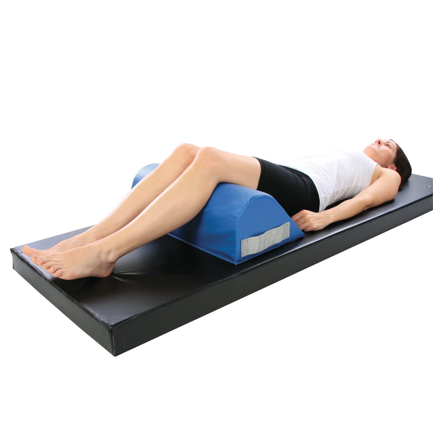 A person lies on a mat using an AliMed Vinyl-Covered Standard Knee Bolster, supporting and elevating their knees.