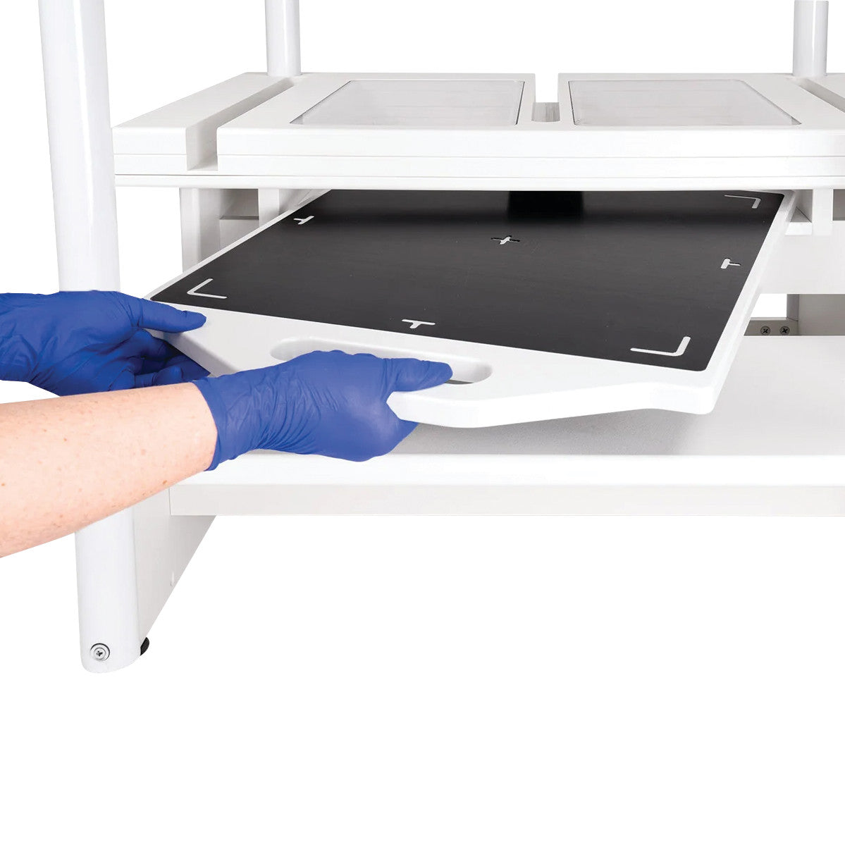 Person with blue gloves positions a "Two-Step Positioning Platform for CR Systems and DR Systems" beneath a machine.