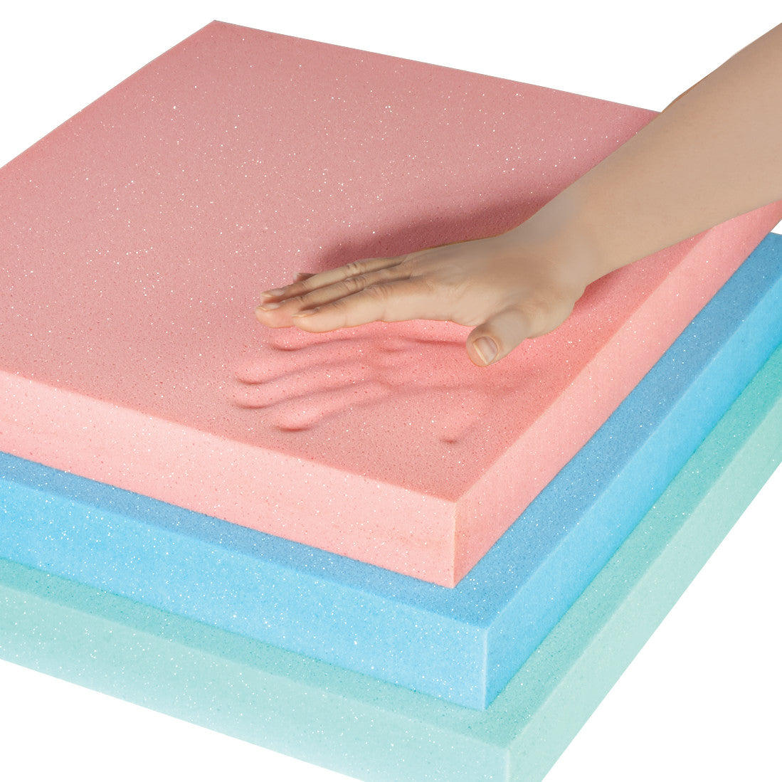 A hand presses into a pink AliMed T-Foam Uncovered Wheelchair Cushion, leaving an imprint. Blue and green foam layers are beneath.