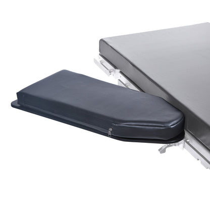 The AliMed Pivoting Armboard attached to a surgical table. It's a dark, padded platform with a zippered cover.