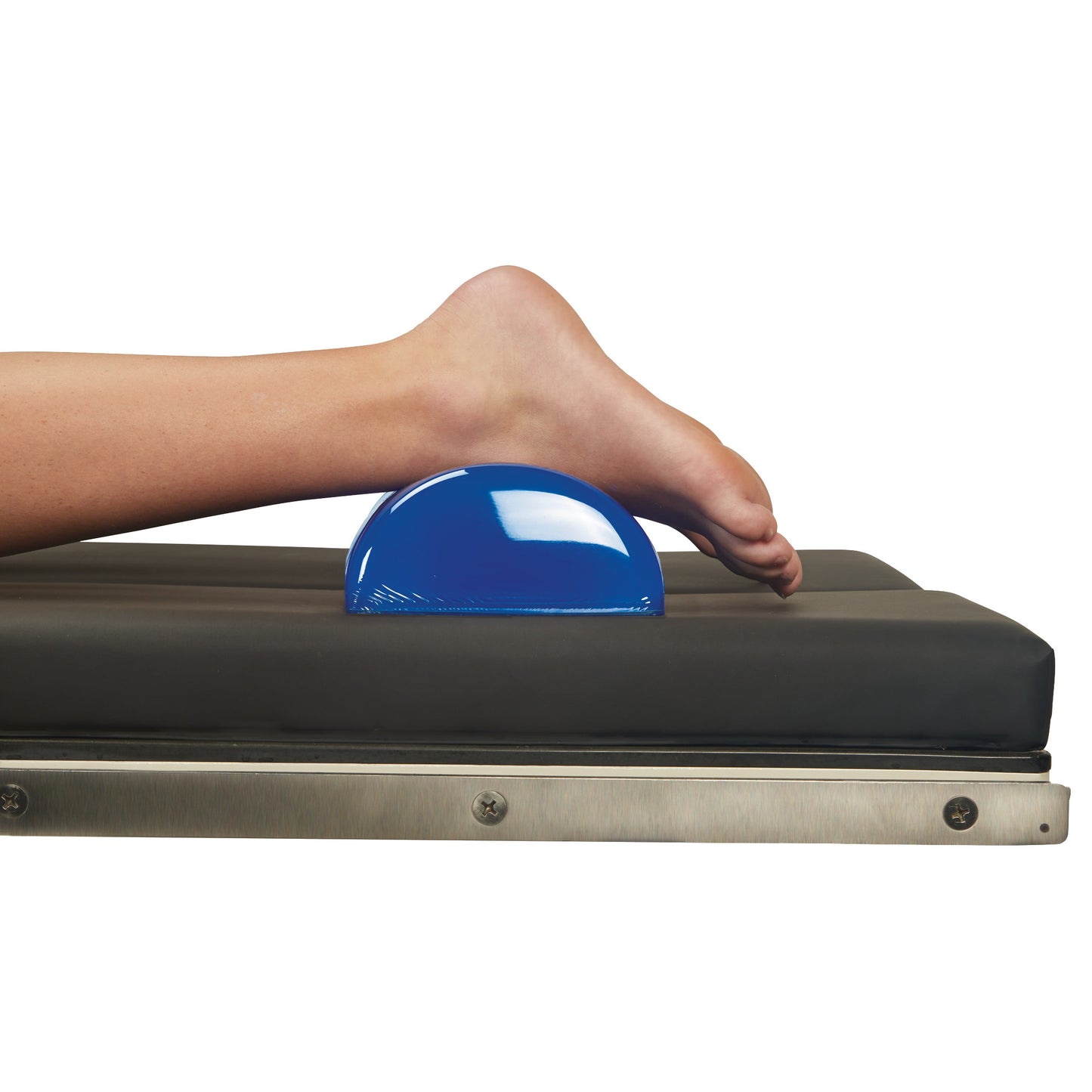 A leg rests on the AliMed AliBlue Gel Dome Positioner on a black padded surface, providing support and elevation.