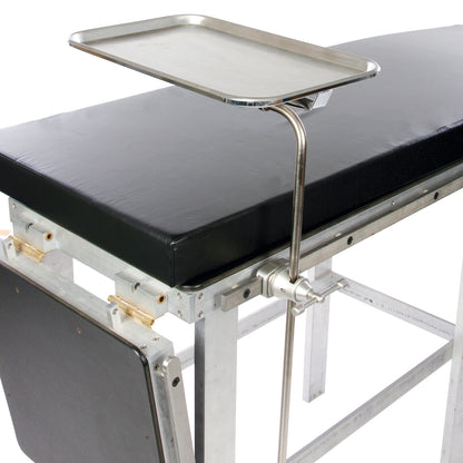 AliMed Side Rail Mounted Mayo Stand attached to a medical table with a black cushion, showcasing an elevated stainless steel tray.