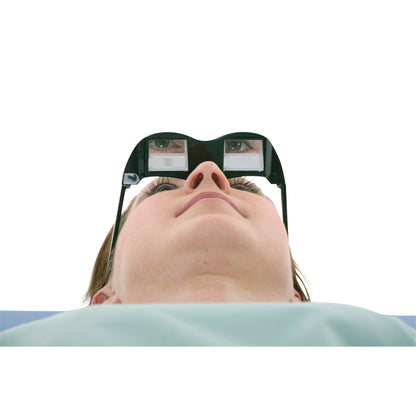 A person wears AliMed Deluxe Prism Glasses while lying down, allowing them to read or watch TV at a 90-degree angle.