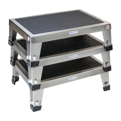 Three stacked Blickman EZ Stacking Stools, made of metal with non-slip surfaces and black corner protectors.
