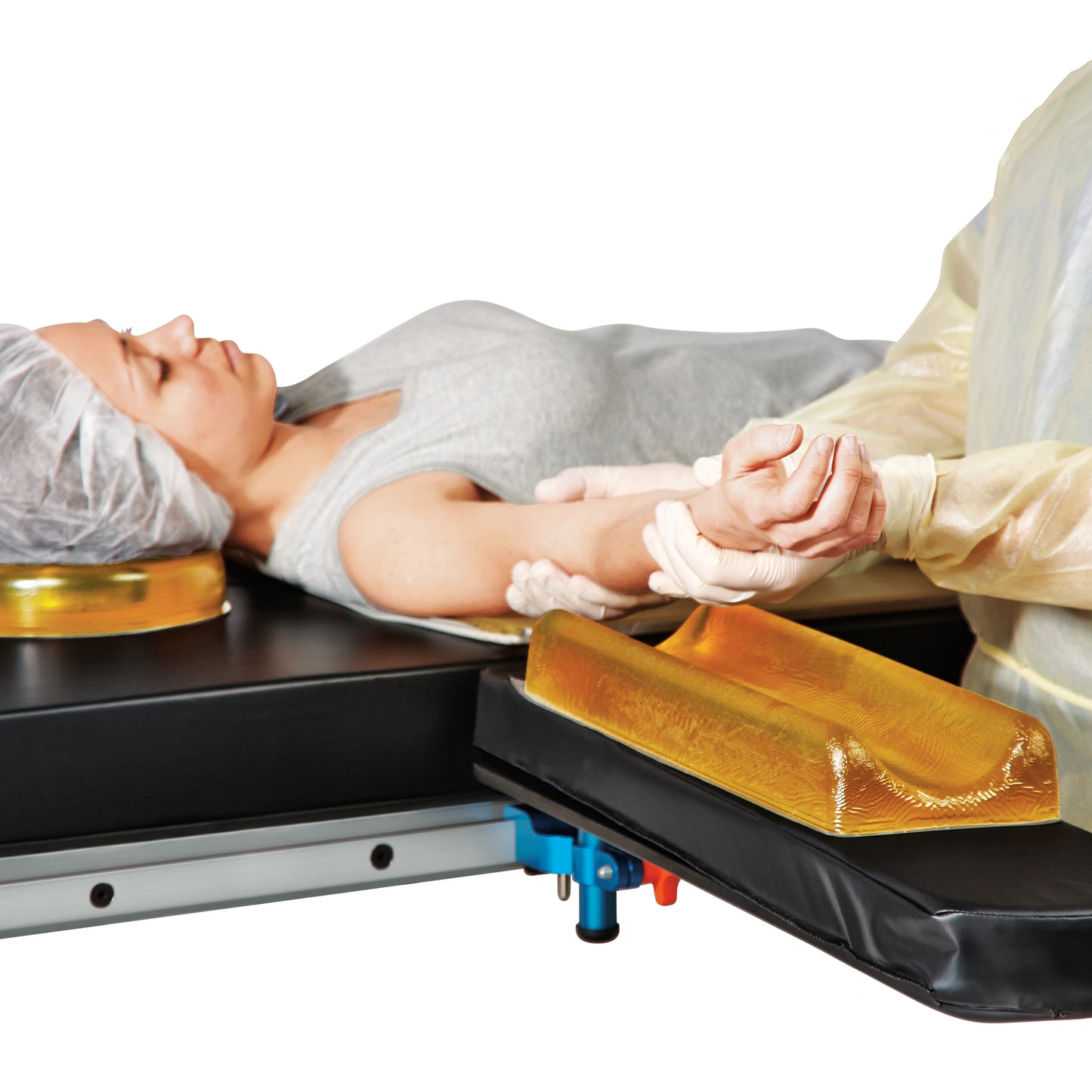 A person lies on a medical table with their arm supported by the AliMed AliGel Contoured Armboard Pad.