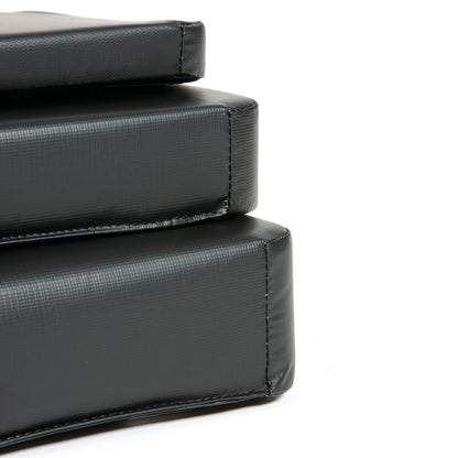 Close-up of stacked black AliMed Standard Armboard Pads, showing their textured surface and stitching.