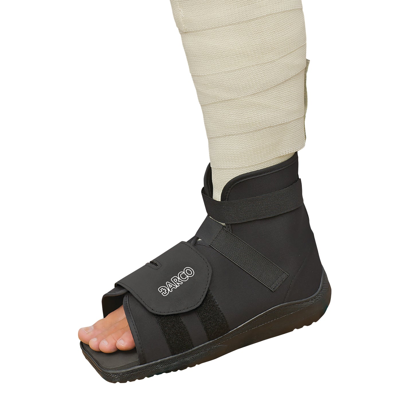A foot wearing a DARCO Slimline Cast Boot with an open-toe design and adjustable straps, paired with a wrapped bandage on the leg.