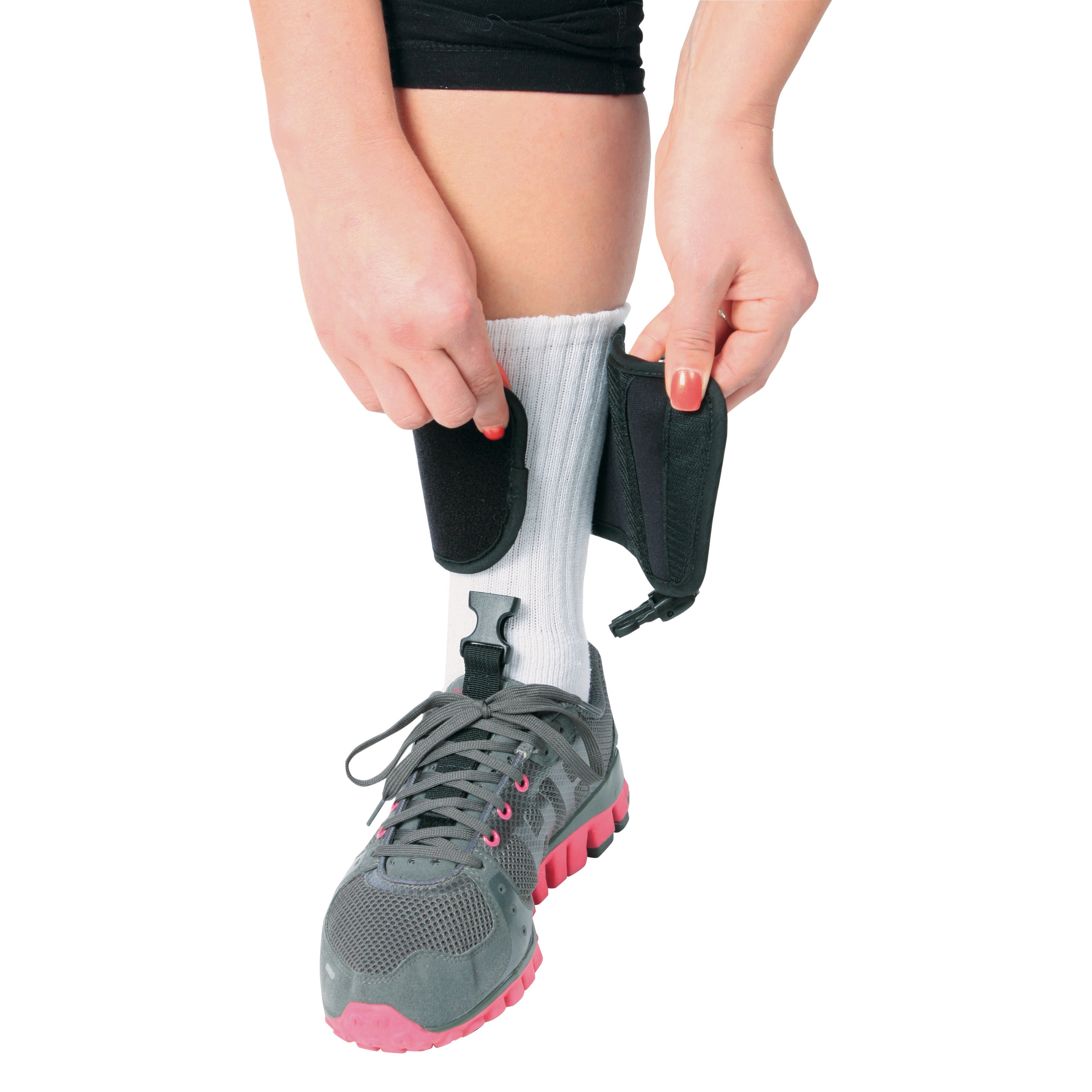 Person adjusts the AliMed FREEDOM Adjustable Footdrop Brace on their leg, wearing a sneaker and white sock.