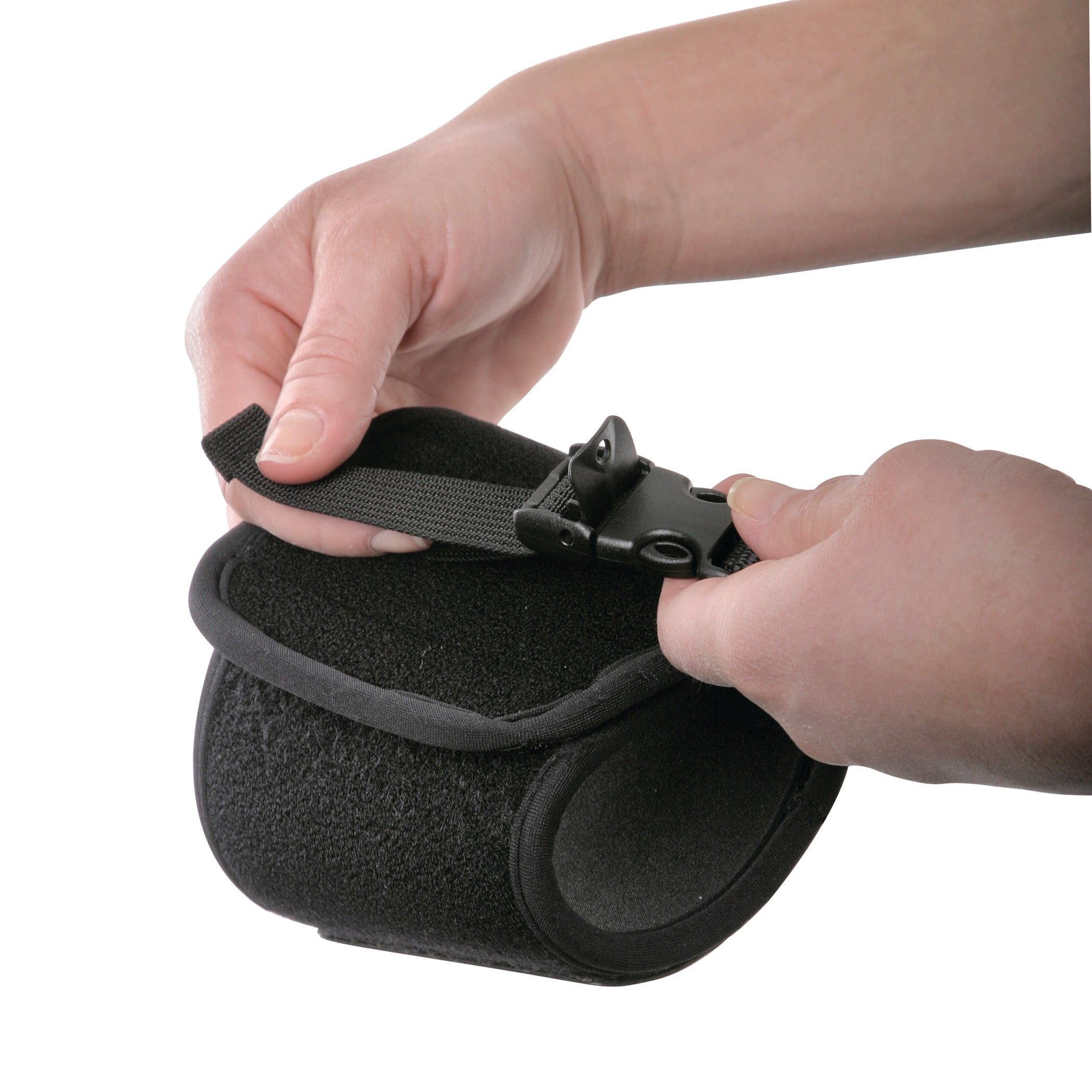 Hands adjusting the AliMed FREEDOM Adjustable Footdrop Brace, a black padded support with a fastening strap and buckle.