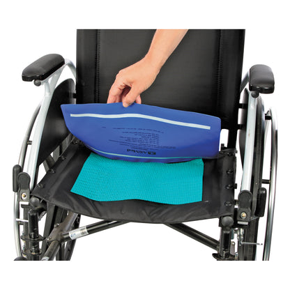 A person places a gel pack on a black wheelchair seat with a blue Posey Grip mat underneath.