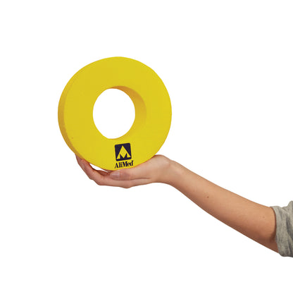 A hand holds a yellow AliMed Protecta-Coat Head Donut with a central hole, featuring the AliMed logo on its surface.