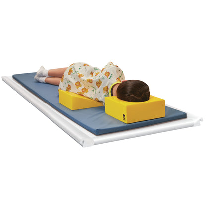 A child lies on a mat using an AliMed Protecta-Coat Occipital Head Support, featuring yellow foam supports for the head and body.