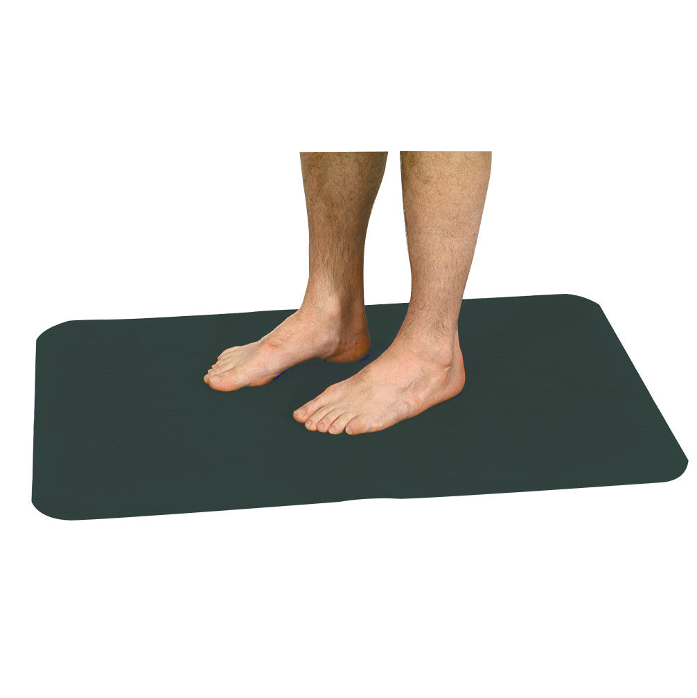 A pair of bare feet standing on an AliMed Safety NoSlip Mat. The mat is black with rounded corners.