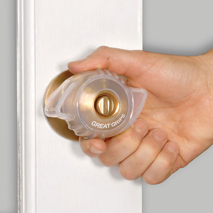 A hand uses a Great Grips cover on a brass doorknob, enhancing grip for easier turning on a white door.