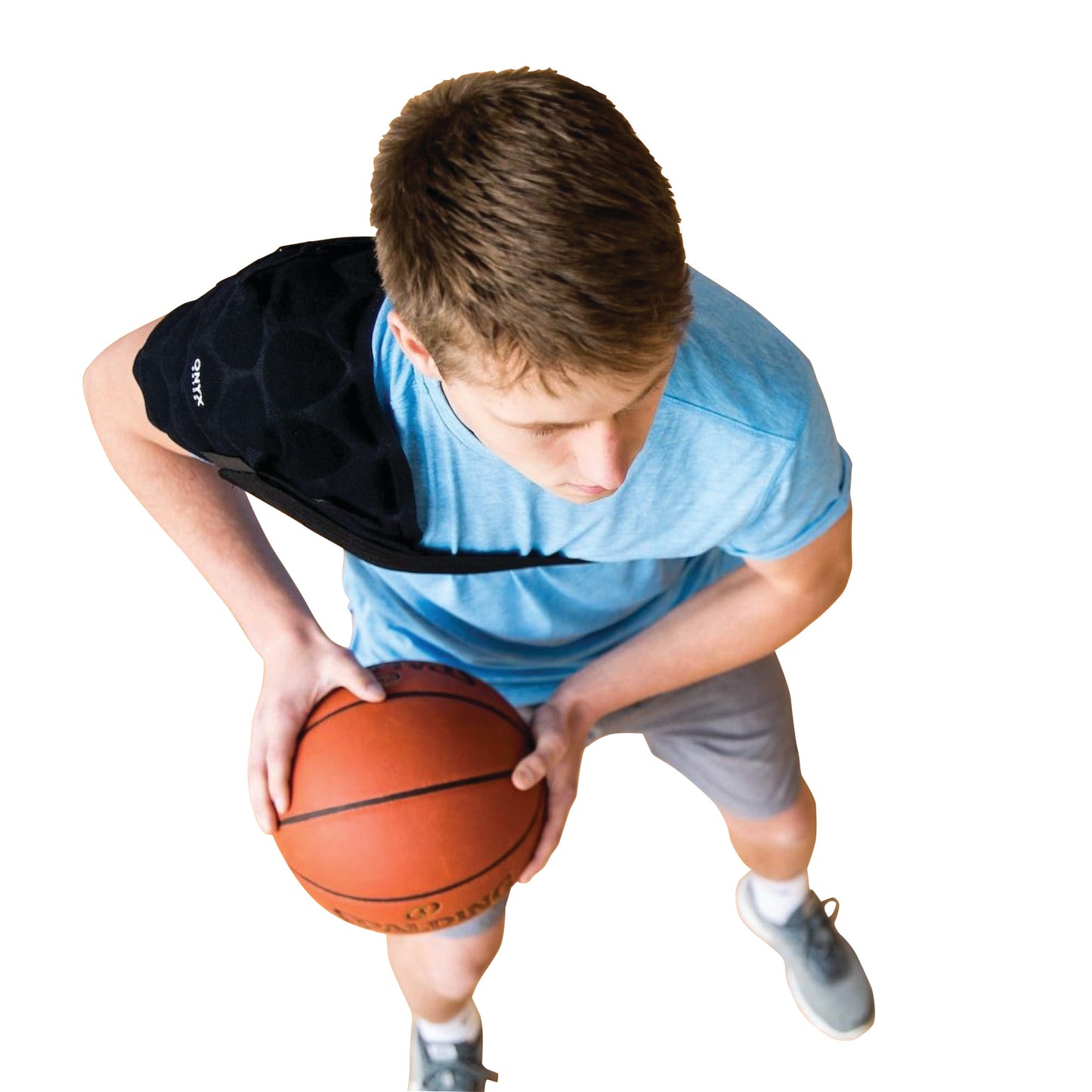 A person wears the Xena Therapies Onyx Cool Shoulder+ while holding a basketball. The shoulder wrap covers their left shoulder.