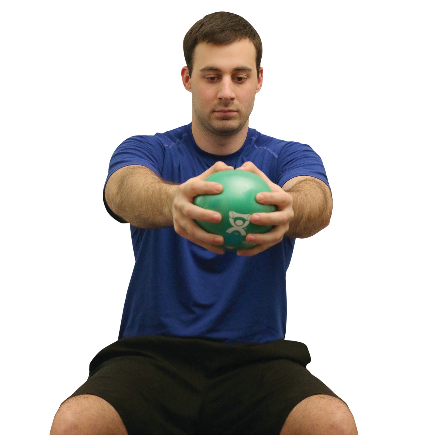 A person demonstrates using the CanDo Hand WaTE Ball, holding a green ball while seated, wearing a blue shirt and black shorts.