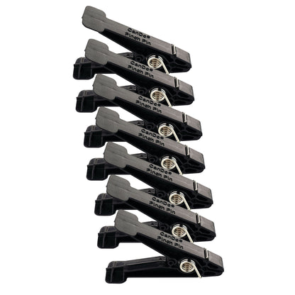 Seven black CanDo Replacement Pins for Finger Pinch Exerciser are arranged in a diagonal row with visible metal springs.
