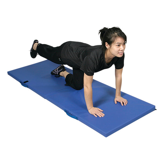 A person exercises on an AliMed Exercise Mat, holding a pose with one leg extended back, on a blue padded surface.