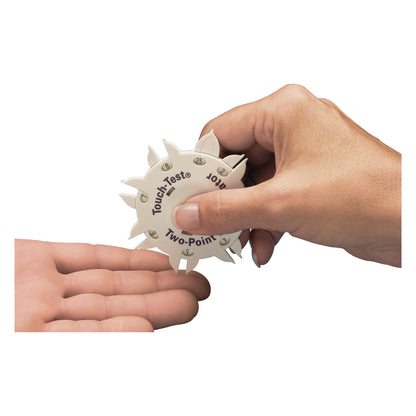 A person uses the Touch-Test Two-Point Discriminator on another's palm, demonstrating its function in sensory testing.