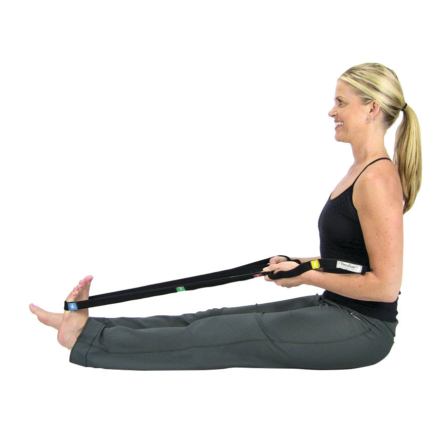 A person stretches their legs using the THERABAND Stretch Strap, sitting with legs extended and the strap looped around the feet.