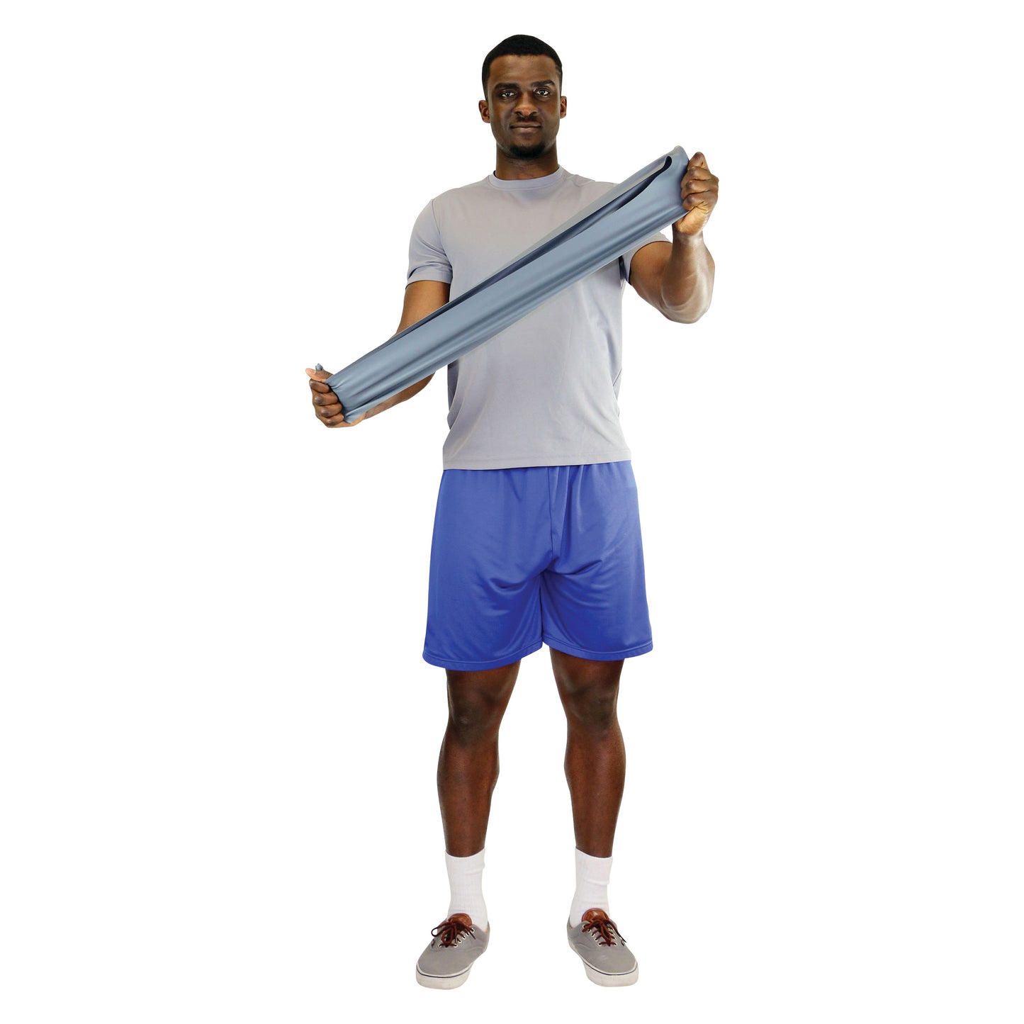 A person holds a CanDo Latex Exercise Band, stretching it between their hands. They wear a gray shirt and blue shorts.