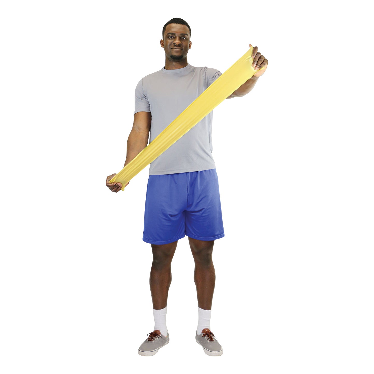 A person stretches a yellow CanDo Non-Latex Exercise Band while standing, wearing a gray shirt and blue shorts.