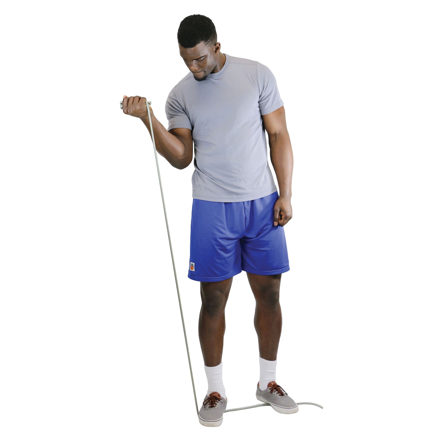 Man uses CanDo Exercise Tubing, standing on it, doing an arm curl. He wears a gray shirt, blue shorts, and gray shoes.