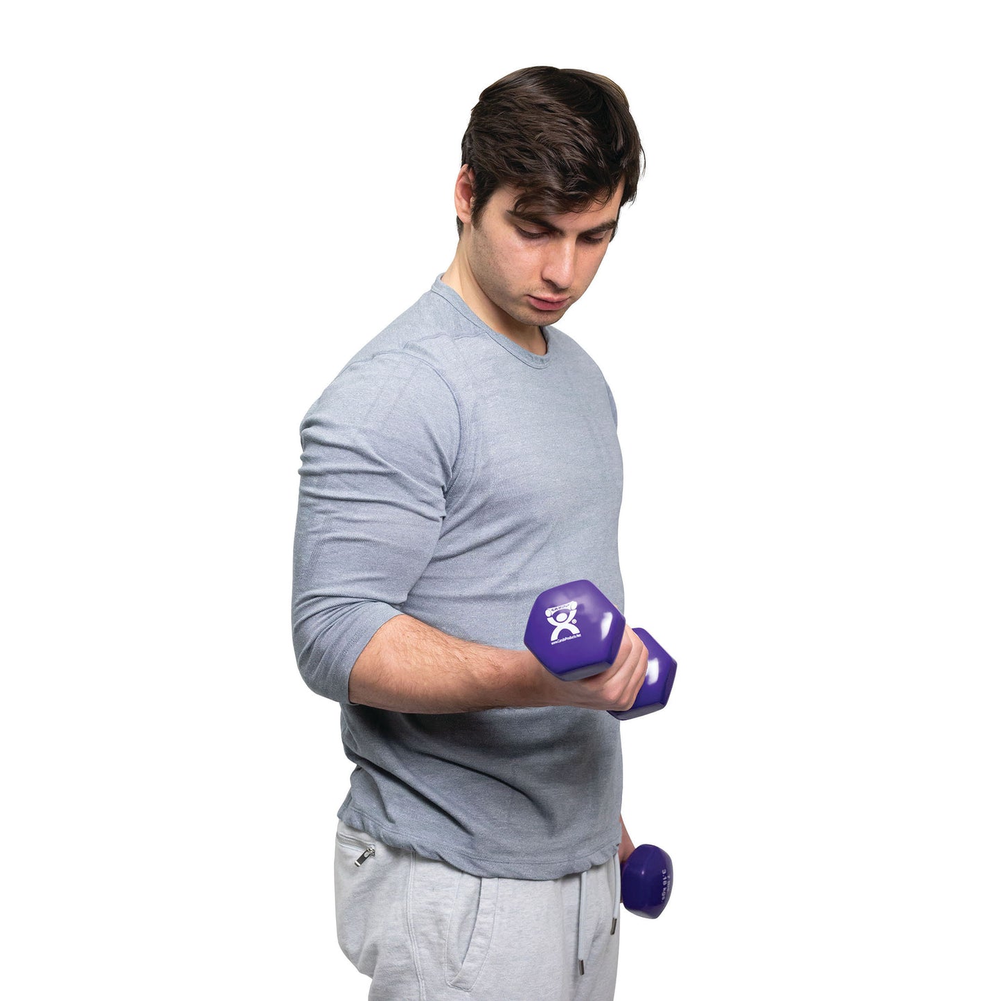 A person lifts a purple CanDo Vinyl-Coated Dumbbell while wearing a light gray shirt and sweatpants against a white background.