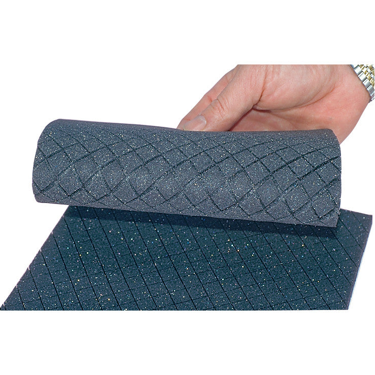 A hand holds a roll of glittery, textured gray Sifoam Padding with a diamond pattern on a flat surface.