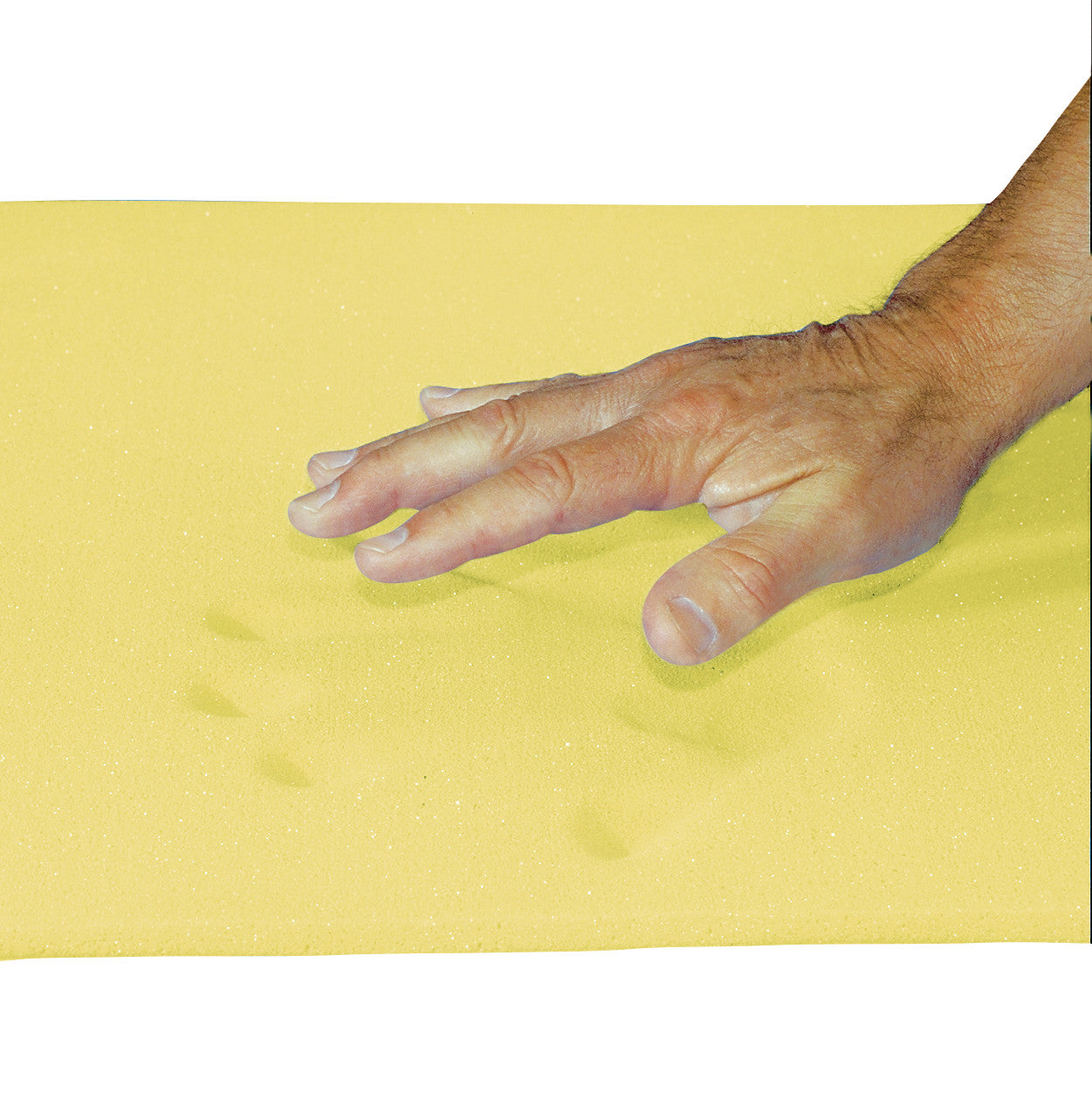 A hand presses into a yellow AliMed T-Foam Sheet, Bed Size, leaving visible impressions on the foam's surface.