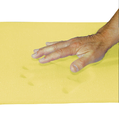 A hand presses into a yellow AliMed T-Foam Sheet, Bed Size, leaving visible impressions on the foam's surface.