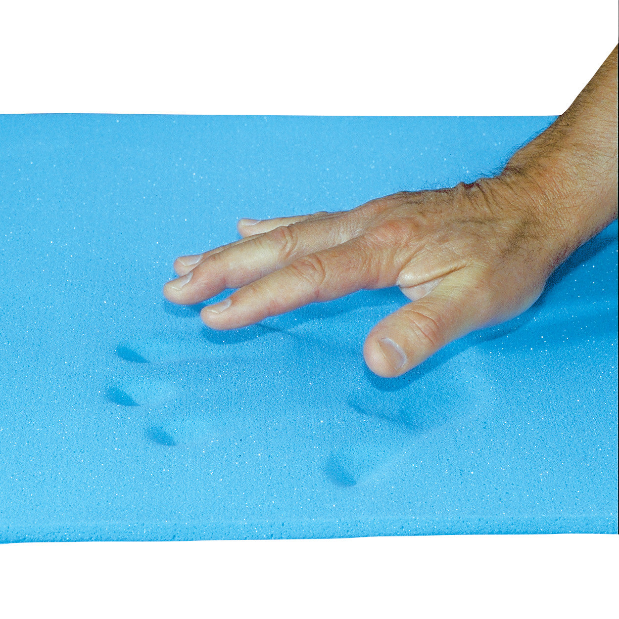 A hand presses into a blue AliMed T-Foam Sheet, Bed Size, leaving an impression, demonstrating its memory foam properties.